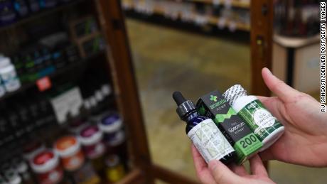 Sarah Shebanek, a wellness buyer for Alfalfa&#39;s, holds some of the CBD oil supplements sold in the Colorado store.